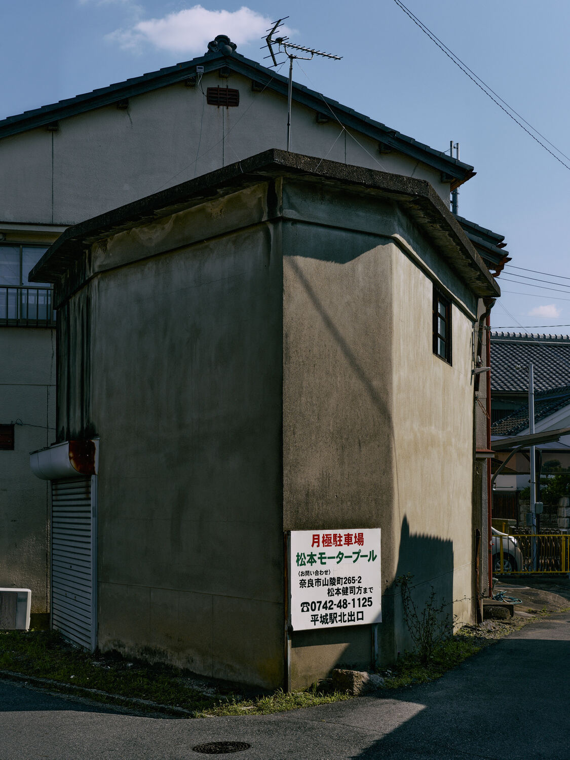 午後の影を映す角の建物