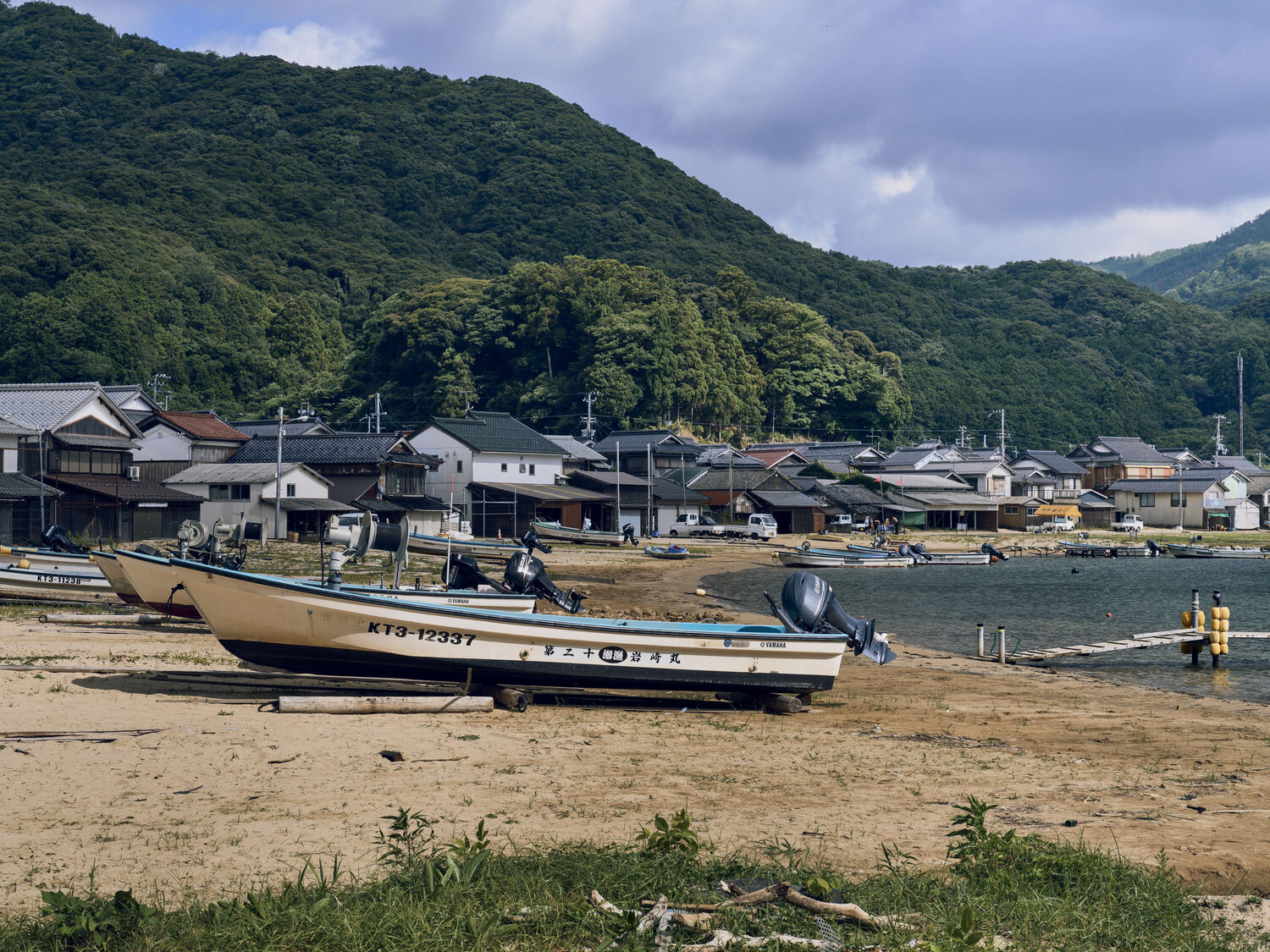 舟と家並みが紡ぐ砂浜の景色