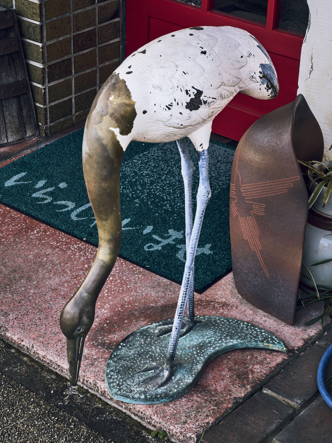 喫茶店の入口で水を探す鶴